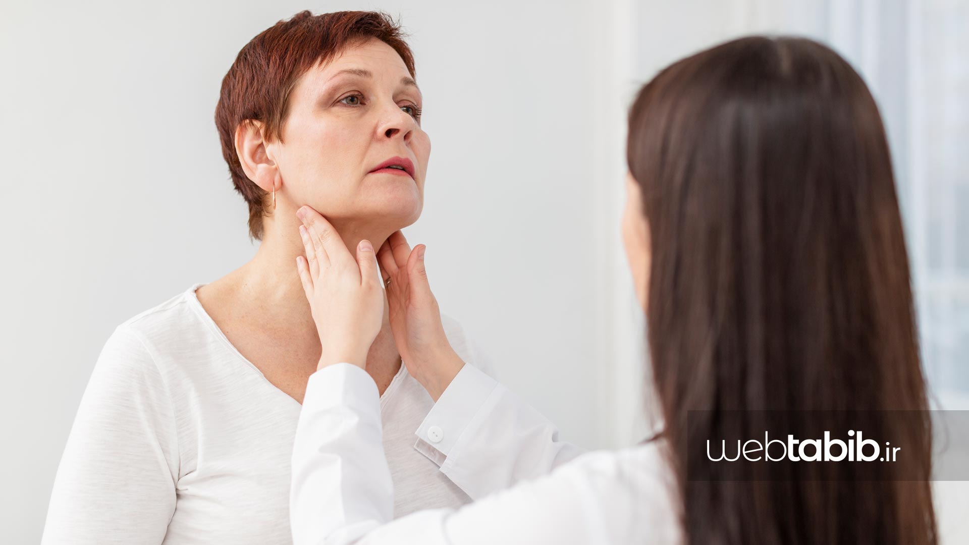 پزشک در حال معاینه‌ تیروئيد در خانمی که T4 بالا در آزمایش داشته است